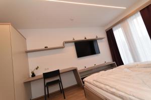 um quarto com uma cama e uma televisão na parede em Village Loft em Sankt Stefan im Rosental