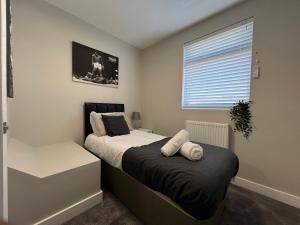 1 Schlafzimmer mit 2 Betten und einem Fenster in der Unterkunft Immaculate Newly Refurbished 4 Bed House in Nottingham