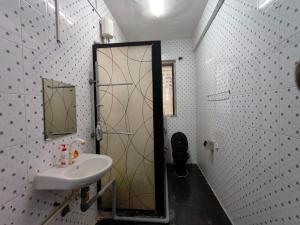 uma casa de banho com um lavatório e um chuveiro com um espelho. em Kritika Accoommdates P G em Mumbai