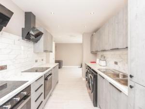 a kitchen with white counters and stainless steel appliances at Pass the Keys Burnley Central Hub Stylish Stay in Burnley