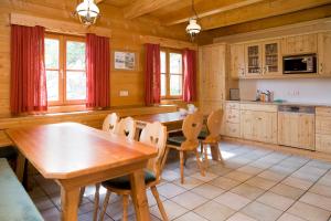 une grande cuisine avec une table et des chaises en bois dans l'établissement Galsterbergalm Jagdhütte, à Auberg