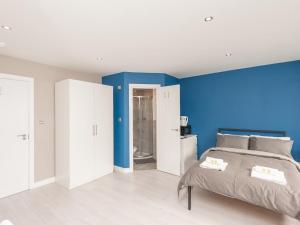 Un dormitorio con una pared de acento azul y una cama en Pass the Keys Burnley Central Hub Stylish Stay en Burnley