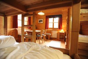 - une chambre avec un lit, une table et des chaises dans l'établissement Galsterbergalm Jagdhütte, à Auberg