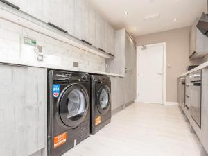 a laundry room with a washer and dryer at Pass the Keys Burnley Central Hub Stylish Stay in Burnley