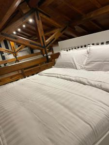 a bedroom with two white beds and a wooden ceiling at Lo Chalet di Ponte Milvio - Auditorium - Foro Italico - Stadio Olimpico in Rome