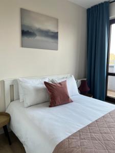 a white bed with two pillows on top of it at TS New Town Top Apartment in Szczecin