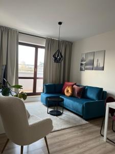 a living room with a blue couch and a window at TS New Town Top Apartment in Szczecin