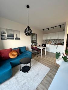 a living room with a blue couch and a dining room at TS New Town Top Apartment in Szczecin