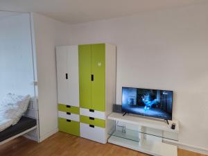- une chambre avec une télévision et une armoire verte et blanche dans l'établissement Ferienwohnung in Köln1901, à Cologne