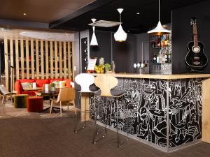 a bar with a black and white drawing on the wall at ibis Valenciennes in Valenciennes