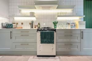 哈羅蓋特的住宿－Luxury Mews House in Harrogate，厨房配有白色橱柜和炉灶烤箱。