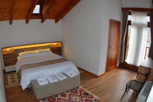 1 dormitorio con 1 cama grande y 1 silla en Sofra Kelmendit, en Tamarë