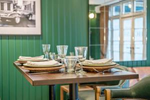 Una mesa con platos y vasos sobre una pared verde. en Luxury Mews House in Harrogate, en Harrogate