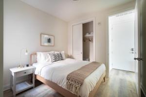 a bedroom with a white bed with a night stand and a door at Dupont Circle 1br w wd nr bars metro station WDC-750 in Washington, D.C.