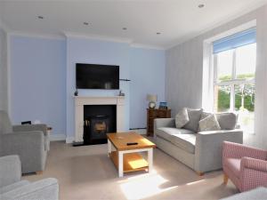 a living room with a couch and a fireplace at Corner House in Sheringham