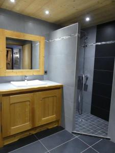 a bathroom with a sink and a shower with a mirror at Auberge des églantiers in Flumet