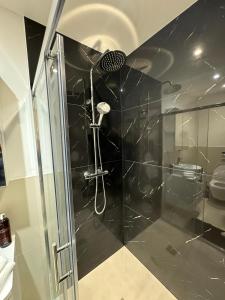a shower with a glass door in a bathroom at Modern 1BD apartment in London