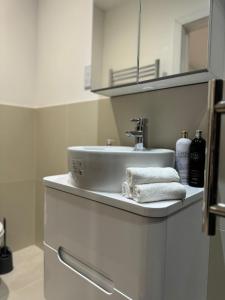 a bathroom with a sink and a counter with towels at Modern 1BD apartment in London