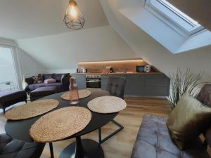 ein Wohnzimmer mit 2 Tischen und eine Küche in der Unterkunft Roof Lounge in Südbrookmerland