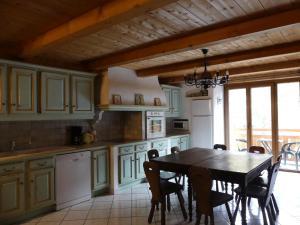 a kitchen with a table and chairs and a dining room at Auberge des églantiers in Flumet