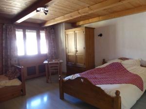 1 dormitorio con cama y techo de madera en Auberge des églantiers, en Flumet