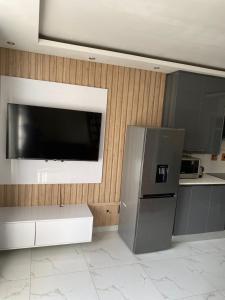 una cucina con frigorifero e TV a schermo piatto di Unit 76 Melville Mews a Johannesburg