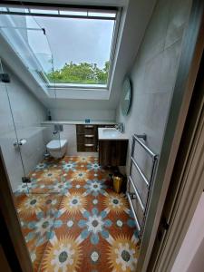 an attic bathroom with a sink and a window at Boutique Linden Gardens 1st floor and loft apartments in London