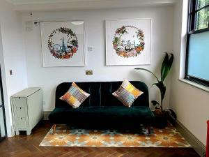salon z zieloną kanapą i dwoma wienkami w obiekcie Boutique Linden Gardens 1st floor and loft apartments w Londynie