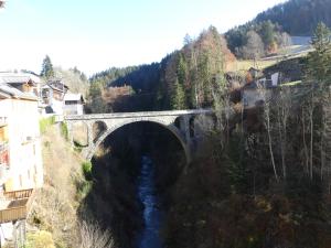 a stone bridge over a river in a town at Auberge des églantiers in Flumet