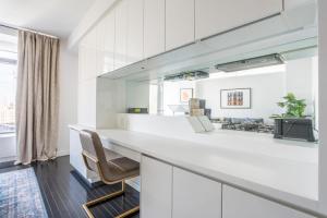 a white kitchen with a counter and a chair at Financial District w WD gym elevator NYC-1360 in New York