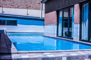 a blue swimming pool next to a building at Coyotes Hotel & Conference Centre in Nelspruit