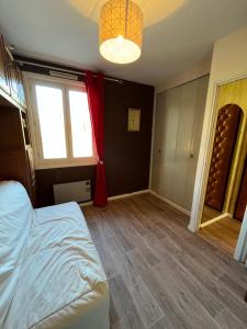 um quarto com uma cama e uma cortina vermelha em Les Sources appartement T2 em Enchastrayes