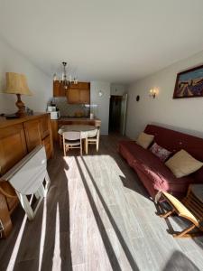 uma sala de estar com um sofá vermelho e uma mesa em Les Sources appartement T2 em Enchastrayes
