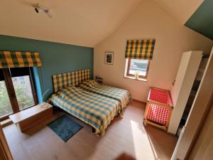 1 dormitorio con 1 cama y 2 ventanas en Gite avec piscine La Buissiere - Fernelmont, en Pontillas