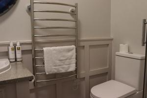 a bathroom with a towel rack next to a toilet at The Gateway Hotel in Kendal