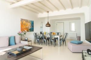 ein Wohnzimmer mit Tisch und Stühlen in der Unterkunft Villa Crystal by Mykonos Mood in Fanari