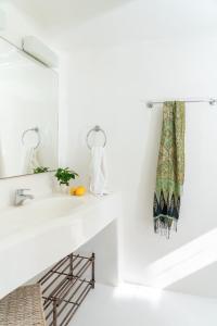Baño blanco con lavabo y espejo en Villa Crystal by Mykonos Mood, en Fanari