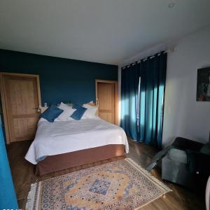 una camera da letto con un grande letto con pareti blu di Gite avec piscine La Buissiere - Fernelmont a Pontillas