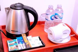 a counter with a coffee maker and water bottles at Kanola Luxury Hotel in Anuradhapura