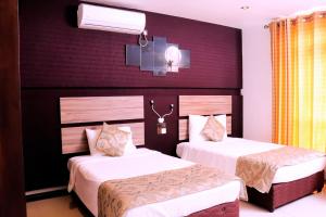 a hotel room with two beds with white sheets at Kanola Luxury Hotel in Anuradhapura