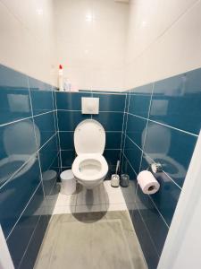 une salle de bains bleue et blanche avec toilettes. dans l'établissement Superbe appartement en centre-ville, 20min de Paris, 5 min d'Enghien, à Saint-Gratien
