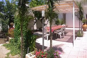 un patio con tavolo, sedie e piante di Arcona a Serrano