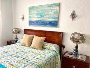 1 dormitorio con 1 cama y una pintura en la pared en Apartamento Isabel By Solymar Holiday, en Mezquitilla