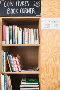 une étagère remplie de livres dans une librairie dans l'établissement Gîte Mozaïk, à Louvain-la-Neuve