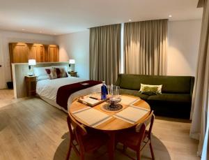 Habitación de hotel con cama, mesa y sofá en Apartamentos Turísticos La Plaza en Chipiona