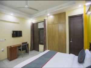 a bedroom with a bed and a desk and a computer at Hotel Logix in Noida