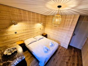 een kamer met een bed in een houten muur bij Appartement Chamonix Centre Vue MontBlanc in Chamonix-Mont-Blanc