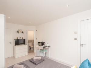 een witte woonkamer met een bureau en een televisie bij Pass the Keys Burnley Central Hub Couples Choice in Burnley