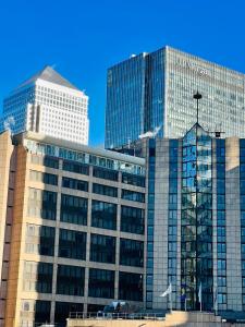 Modern Canary studio- Wifi في لندن: مبنيان زجاجيان طويلان أمام السماء الزرقاء