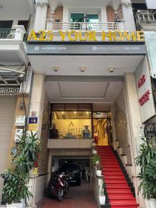 einen Hoteleingang mit einer roten Treppe und einem Schild, das Ihr Haus liest in der Unterkunft A25 Hotel - 44 Hàng Bún in Hanoi